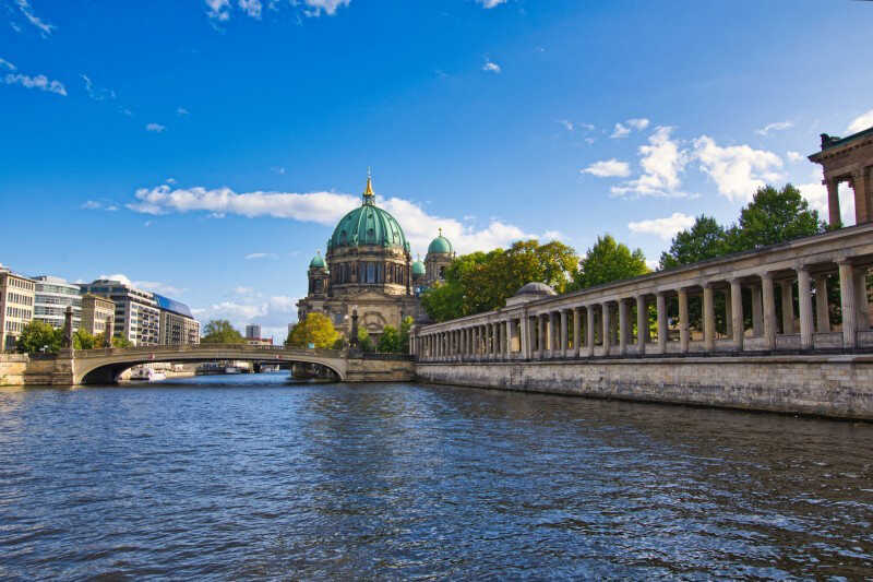 Die Spree führt durch Berlin mit Blick auf den Berliner Dom, eine Brücke und die historische Kolonnade am Ufer.