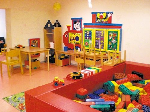 Kinderspielzimmer mit bunten Bauklötzen, Spielzeug und Tischen.